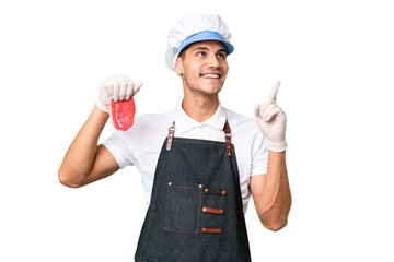 Butcher caucasian man wearing an apron and serving fresh cut meat over isolated background pointing up a great idea