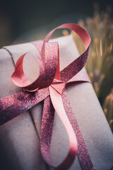 Close-up of christmas gift in green pine tree. bokeh light in the background. sustainable xmas...