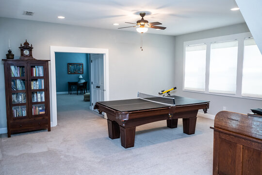 An upstairs loft air used as a bonus game room with a pool table and cabinet