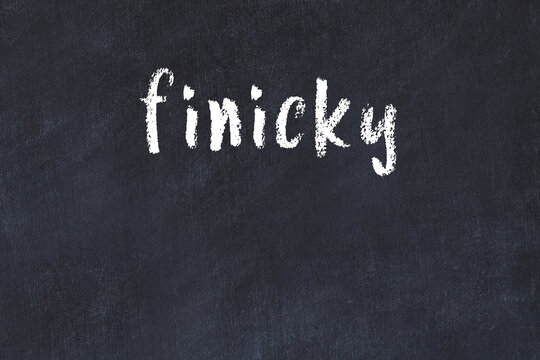 College chalk desk with the word finicky written on in