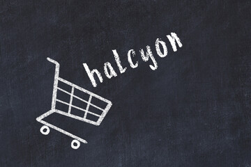 Chalk drawing of shopping cart and word halcyon on black chalboard. Concept of globalization and mass consuming