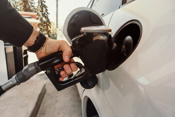 Refueling the car at a gas station fuel pump. Man driver hand refilling and pumping gasoline oil the car with fuel at he refuel station. Car refueling on petrol station. Fuel pump at station