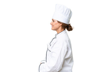 Middle-aged chef woman over isolated background in lateral position