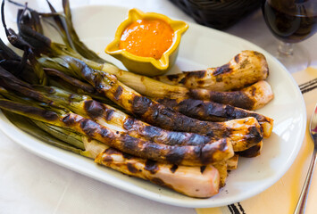 Grilled calcots with romesco sauce. National Catalan winter dish served in restaurant