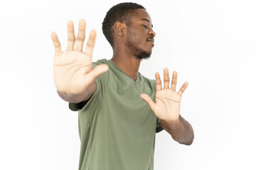 Dissatisfied young man showing refusal with his hands. Male African American model in green T-shirt...