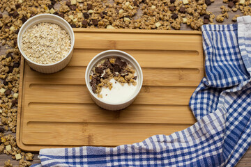 Granola in a bowl surrounded by granola on table. Granola background
