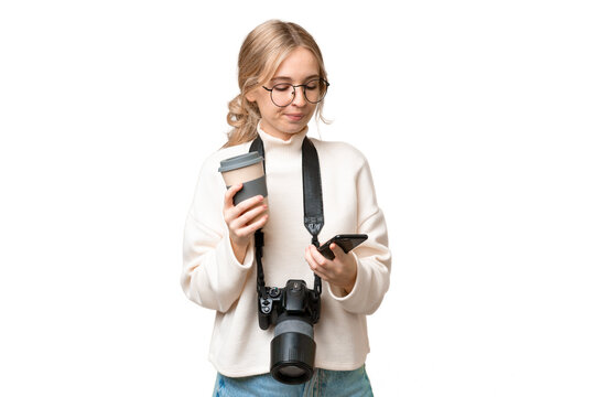 Young photographer English woman over isolated background holding coffee to take away and a mobile