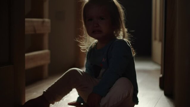 domestic violence. little girl crying and sobing in the morning at home. punished in the corner crying tears. domestic kid abuse fear concept. autistic child is punished and beaten afraid of fear
