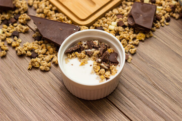 Granola in a bowl surrounded by granola on table. Granola background