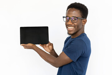 Happy man holding tablet horizontally. Young African American male model presenting something on tablet screen. Portrait, studio shot, technology, advertising concept