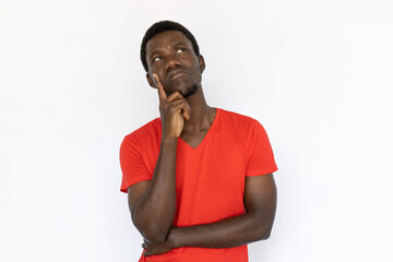 Thoughtful man contemplating. Young African American male model holding finger on cheek and thinking. Portrait, studio shot, thoughtfulness concept