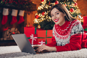 Photo of adorable positive lady lying floor using modern device order courier delivery holiday dinner enjoy winter time house indoors