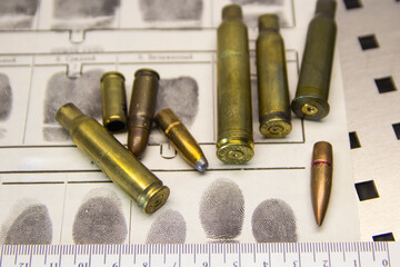 Bullets, cartridge cases, cartridges lie on a fingerprint card close-up