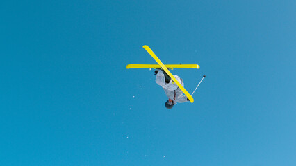 LOW ANGLE VIEW: Young male athlete jumping big air in snow park at ski resort