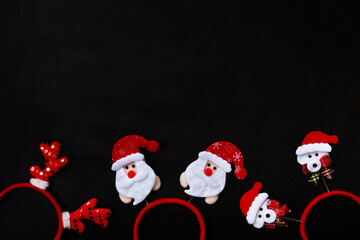 Christmas headbands on a dark wooden background, top view. Christmas or New Year background with empty space