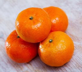 Closeup of four fresh whole clementines on wooden background. Concept of health benefits of citrus © JackF