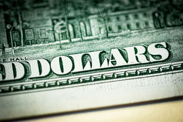 The inscription "dollars" close-up on a paper bill of the old 100 American dollars. Macro photo with beautiful bokeh.