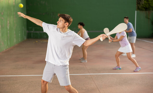 Caucasian teenage boy in sportswear playing paleta fronton on outdoor court