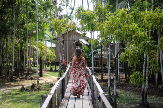 Mulher n&atilde;o identificada caminhando em palafitas de hotel de selva no amazonas 