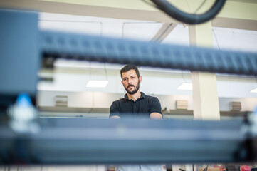 Professional worker printmaker technician operator works in printing press hall and printshop...