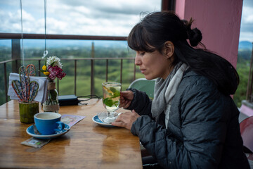 A Young Bolivian Woman Drinks Herbal Tea in a Restaurant