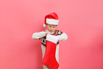 Merry Christmas! Young girl celebrating Christmas against pink background