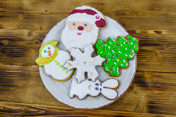 Christmas gingerbread cookies in a plate on a wooden table. Top view