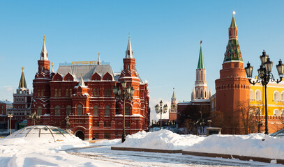 Scenic view of snow covered Manezhnaya Square overlooking building of State Historical Museum and corner Arsenal Tower of Moscow Kremlin, Russia..