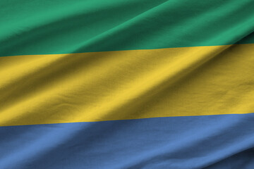 Gabon flag with big folds waving close up under the studio light indoors. The official symbols and...