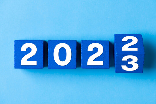 2023 Happy New Year. Wooden cube block change from 2022 to 2023 on blue. Concept 2023 New Year background. Business, resolutions, goals, inspiration, success, ideas