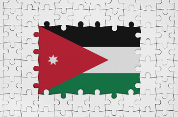 Jordan flag in frame of white puzzle pieces with missing central part