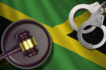 Jamaica flag with judge mallet and handcuffs in dark room. Concept of criminal and punishment,...