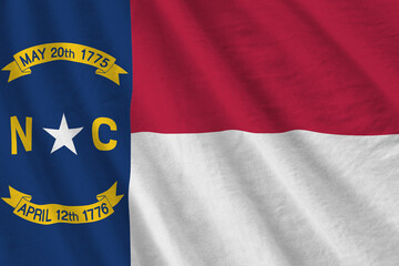 North Carolina US state flag with big folds waving close up under the studio light indoors. The...