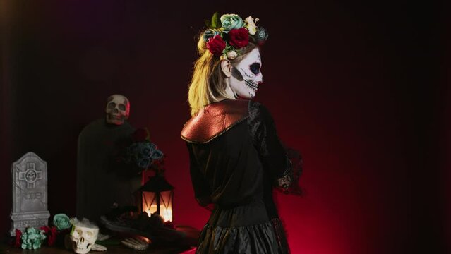 Scary horror woman trying to lure with hand, reach and tempt victims in studio. Flirty la cavalera catrina model with mexican festival costume on holiday celebration, day of the dead.