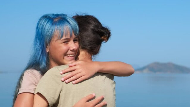 Warm parent hugging during trip. A daughter hugs her mother with love on sunny shore during summer traveling by sea.