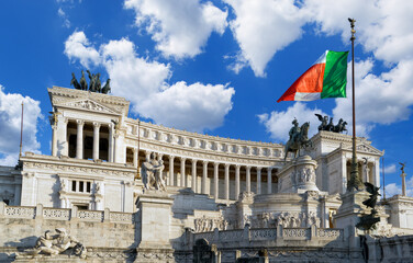 Fototapeta na wymiar Beautiful view of a Vittoriano - monument in honor of Victor Emmanuel II with a flag of Italy against a blue sky in the sunny day. Rome, Italy 