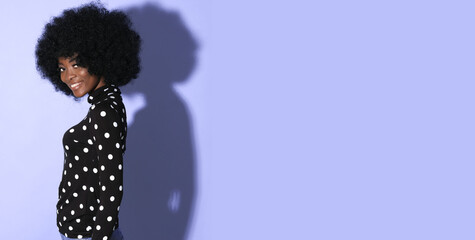 Happy African female model on violet background.