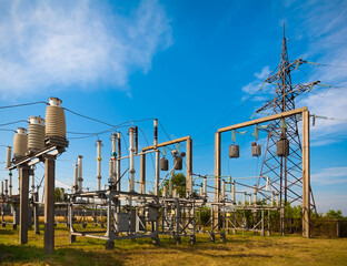 Summer. Electrical substation against the sky with clouds. In the frame insulators, transformer,...