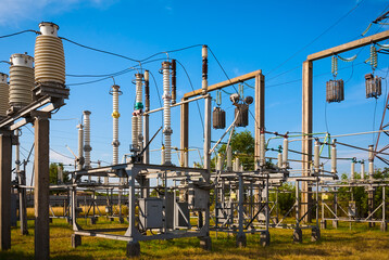 Summer. Electrical substation against the sky with clouds. In the frame insulators, transformer,...