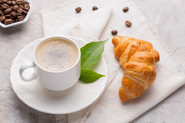 Coffee glass, roasted coffee beans and bread on the white table