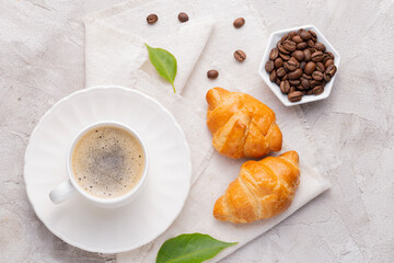 Coffee glass, roasted coffee beans and bread on the white table