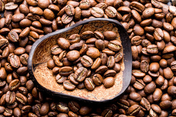 Roasted coffee beans with wooden spoon, closeup image, space for text