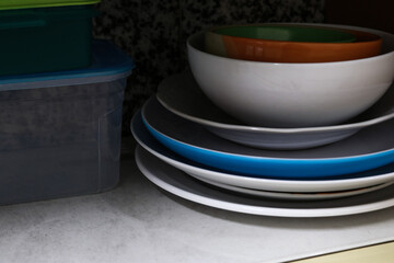 Piles of plates and glasses in the kitchen of an apartment or house