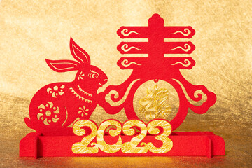 Chinese New Year of Rabbit mascot paper cut on golden background translation of the Chinese words...