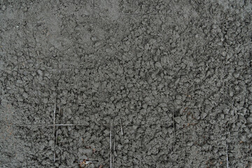 Above view of construction background. Cement mixed with stone is poured onto the steel grid structure.