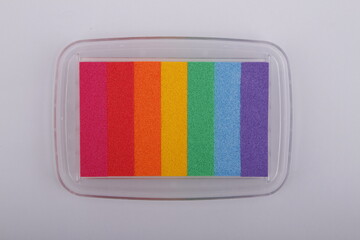 Rainbow colored stamp pad against a white background