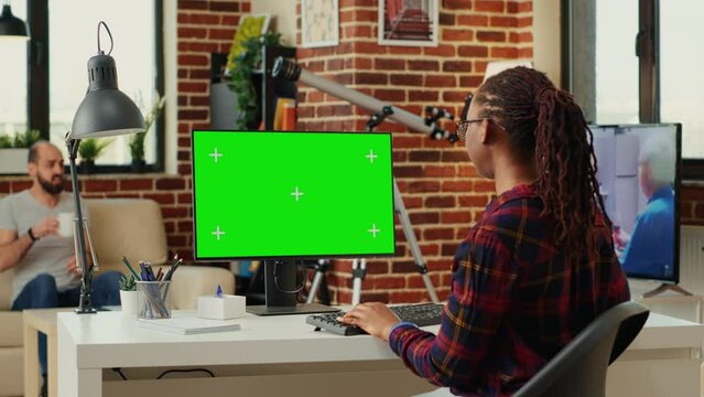 Office worker analyzing isolated greenscreen template on personal computer, looking at blank chroma key display on monitor. Watching pc desktop with mock up copy space background. Tripod shot.
