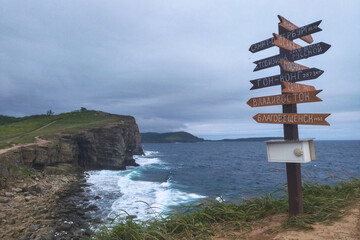 Vladivostok, Russia-July 6, 2022: An unusual art object on promontory Tobizina, Russian Island. A sign post with different cities and the distance to them