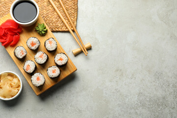 Tasty sushi rolls served on grey table, flat lay. Space for text