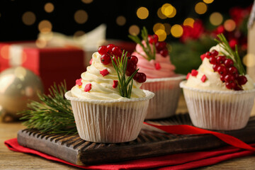 Delicious cupcakes and Christmas decorations on wooden table